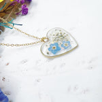 Collana artigianale ciondolo cuore con fiori veri in resina – nontiscordardimè azzurri e pizzo della regina Anna, acciaio oro