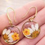 Orecchini cerchi piccoli pendenti acciaio fiori veri Margherita in resina opale fiori arancio. Gioielli fiori veri essiccati pressati.