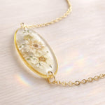 Collana donna pendente ovale fiori veri bianchi essiccati pressati in resina. Gioielli fiori veri resina. Ciondolo oro fiore. Regalo unico