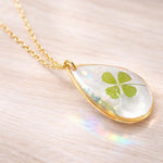 Collana donna ciondolo fiore vero quadrifoglio portafortuna scaglie opale in resina.Catenella acciaio dorato Gioielli botanical terrarium.