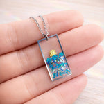Collana fiori veri in resina trasparente – Ciondolo rettangolare blu e foglia oro, gioiello floreale handmade, regalo per lei