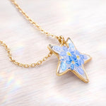Collana con fiore vero forget me not/nontiscordardimé, pendente a stella, resina UV, catena in acciaio placcato oro, stile botanico/boho