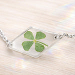 Terrarium woman bracelet real flower four-leaf clover lucky charm Resin pendant adjustable steel chain one size.Resin jewels