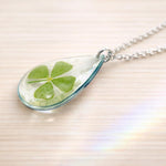 Collana donna ciondolo fiore vero quadrifoglio portafortuna scaglie opale in resina.Catenella acciaio dorato Gioielli botanical terrarium.